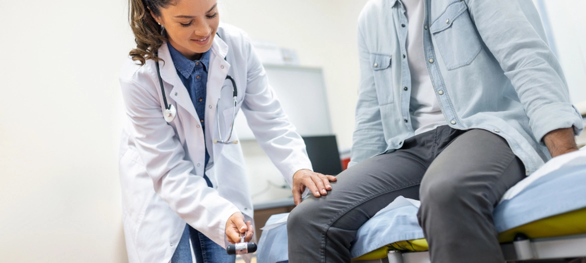 Podiatrist checking a patient's leg reflexes during an in-office foot and ankle exam